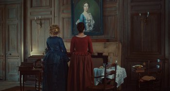 Movie still from “Portrait of a Lady on Fire” (2019), directed by Céline Sciamma – Two women are standing in front of a painting; Wide shot, Over the shoulder angle
