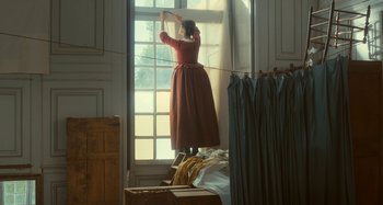 Movie still from “Portrait of a Lady on Fire” (2019), directed by Céline Sciamma – A woman standing in front of a large window; Wide shot, Low angle