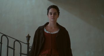 Movie still from “Portrait of a Lady on Fire” (2019), directed by Céline Sciamma – A woman in a brown dress and a brown coat; Medium shot, Low angle