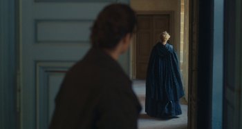 Movie still from “Portrait of a Lady on Fire” (2019), directed by Céline Sciamma – A woman in a blue dress and a man in a brown suit; Wide shot, Over the shoulder angle