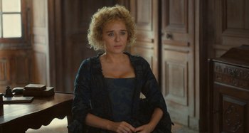 Movie still from “Portrait of a Lady on Fire” (2019), directed by Céline Sciamma – A woman sitting in a chair in a room; Medium shot, High angle