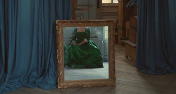 Movie still from “Portrait of a Lady on Fire” (2019), directed by Céline Sciamma – A woman in a green dress sitting in front of a mirror; Medium shot, Over the shoulder angle