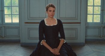 Movie still from “Portrait of a Lady on Fire” (2019), directed by Céline Sciamma – A woman in a black dress sitting on the floor; Medium shot, High angle