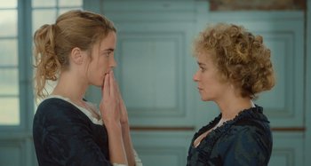Movie still from “Portrait of a Lady on Fire” (2019), directed by Céline Sciamma – Two women one of whom is holding her hand up to her face; Close Up shot, Over the shoulder angle
