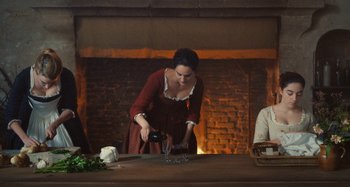 Movie still from “Portrait of a Lady on Fire” (2019), directed by Céline Sciamma – A woman pouring wine into a wine glass in front of a fire place; Medium shot, High angle