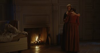 Movie still from “Portrait of a Lady on Fire” (2019), directed by Céline Sciamma – Two people in a living room near a fire place; Wide shot, Over the shoulder angle