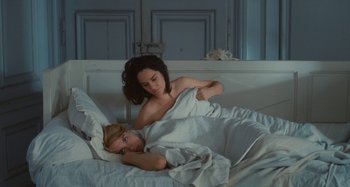 Movie still from “Portrait of a Lady on Fire” (2019), directed by Céline Sciamma – Two women in a bed , one of which is laying in bed; Medium shot, Overhead angle