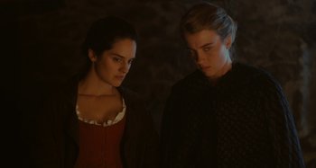 Movie still from “Portrait of a Lady on Fire” (2019), directed by Céline Sciamma – Two people standing next to each other in the dark; Medium shot, Over the shoulder angle