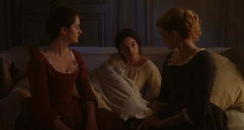 Movie still from “Portrait of a Lady on Fire” (2019), directed by Céline Sciamma – A group of women sitting on top of a couch; Medium shot, High angle