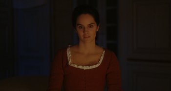 Movie still from “Portrait of a Lady on Fire” (2019), directed by Céline Sciamma – A woman in a red dress is standing in a room; Medium shot, Over the shoulder angle