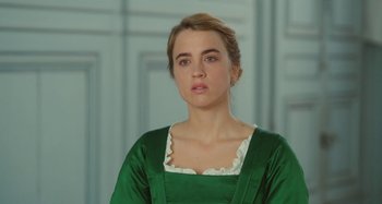 Movie still from “Portrait of a Lady on Fire” (2019), directed by Céline Sciamma – A woman in a green dress is looking at the camera; Close Up shot, Over the shoulder angle