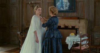 Movie still from “Portrait of a Lady on Fire” (2019), directed by Céline Sciamma – A woman is helping another woman put on a wedding dress; Medium shot, Over the shoulder angle