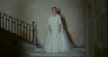 Movie still from “Portrait of a Lady on Fire” (2019), directed by Céline Sciamma – A woman in a wedding dress standing on steps; Wide shot, Low angle
