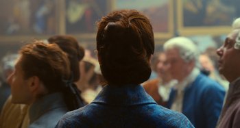 Movie still from “Portrait of a Lady on Fire” (2019), directed by Céline Sciamma – A woman in a blue jacket standing in front of a group of people; Medium shot, Over the shoulder angle