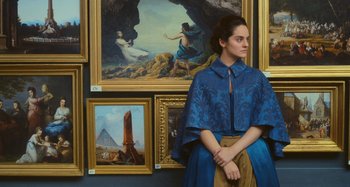 Movie still from “Portrait of a Lady on Fire” (2019), directed by Céline Sciamma – A woman sitting in front of a wall of paintings; Medium shot, Low angle