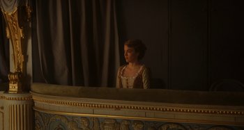 Movie still from “Portrait of a Lady on Fire” (2019), directed by Céline Sciamma – A woman in a dress looking into a mirror; Medium shot, Over the shoulder angle