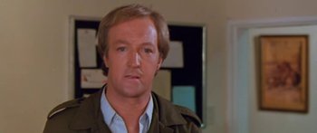 Movie still from “The Gods Must Be Crazy” (1980), directed by Jamie Uys – A person wearing a shirt and jacket; Close Up shot, Low angle