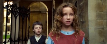 Movie still from “The Golden Compass” (2007), directed by Chris Weitz – A boy and a girl standing next to each other in front of an archway; Close Up shot, Low angle