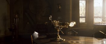 Movie still from “The Golden Compass” (2007), directed by Chris Weitz – An antique microscope sitting on top of a wooden table; Medium shot, High angle