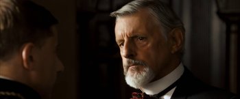 Movie still from “The Golden Compass” (2007), directed by Chris Weitz – An older man wearing a red bow tie and a white beard; Close Up shot, Low angle