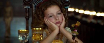 Movie still from “The Golden Compass” (2007), directed by Chris Weitz – A young girl sitting in a chair with her hands on her face; Close Up shot, High angle