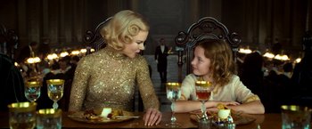 Movie still from “The Golden Compass” (2007), directed by Chris Weitz – A woman sitting at a table with a young girl; Medium shot, Over the shoulder angle