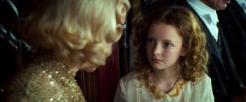 Movie still from “The Golden Compass” (2007), directed by Chris Weitz – A young girl looking at another young girl in front of a mirror; Close Up shot, Over the shoulder angle