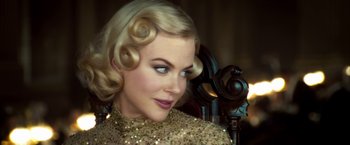 Movie still from “The Golden Compass” (2007), directed by Chris Weitz – A woman with blonde hair is wearing a gold dress; Close Up shot, Over the shoulder angle