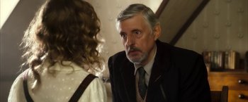Movie still from “The Golden Compass” (2007), directed by Chris Weitz – An older man in a suit and tie talking to a young woman; Close Up shot, Over the shoulder angle