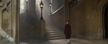 Movie still from “The Golden Compass” (2007), directed by Chris Weitz – A woman in a red coat standing in front of a staircase; Wide shot, High angle