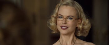 Movie still from “The Golden Compass” (2007), directed by Chris Weitz – A woman with blonde hair wearing glasses and a necklace; Close Up shot, Over the shoulder angle