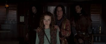 Movie still from “The Golden Compass” (2007), directed by Chris Weitz – A woman and a girl are standing in a dark room; Medium shot, Low angle