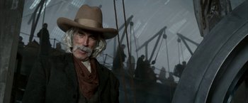 Movie still from “The Golden Compass” (2007), directed by Chris Weitz – A man with a beard and a hat on; Close Up shot, Over the shoulder angle