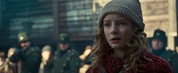 Movie still from “The Golden Compass” (2007), directed by Chris Weitz – A young woman wearing a hat and a scarf; Close Up shot, Over the shoulder angle