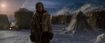 Movie still from “The Golden Compass” (2007), directed by Chris Weitz – A woman in a parka standing in the middle of a snow covered field; Medium shot, Low angle