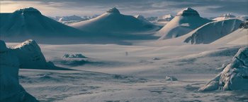 Movie still from “The Golden Compass” (2007), directed by Chris Weitz – A person is walking through the snow on a mountain; Extreme Wide shot, High angle