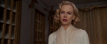 Movie still from “The Golden Compass” (2007), directed by Chris Weitz – A woman with blonde hair wearing a white shirt and scarf; Close Up shot, Over the shoulder angle