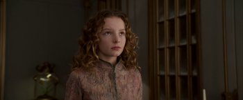Movie still from “The Golden Compass” (2007), directed by Chris Weitz – A young girl with long curly red hair looking to her left; Close Up shot, High angle
