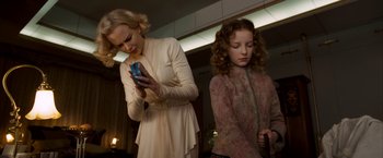 Movie still from “The Golden Compass” (2007), directed by Chris Weitz – A woman and a girl looking at a cell phone; Medium shot, Low angle