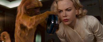 Movie still from “The Golden Compass” (2007), directed by Chris Weitz – A woman holding a monkey in front of a mirror; Close Up shot, Over the shoulder angle