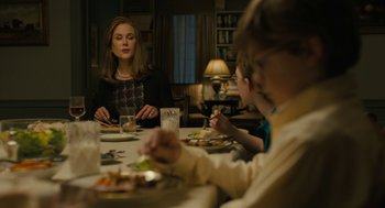 Movie still from “The Goldfinch” (2019), directed by John Crowley – A woman sitting at a table with two children; Medium shot, Over the shoulder angle