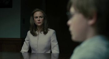 Movie still from “The Goldfinch” (2019), directed by John Crowley – A woman sitting in front of a man in front of a mirror; Close Up shot, Over the shoulder angle