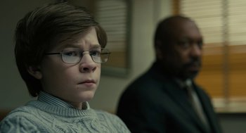 Movie still from “The Goldfinch” (2019), directed by John Crowley – A young boy wearing glasses sitting next to an older man; Close Up shot, Over the shoulder angle