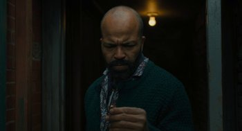 Movie still from “The Goldfinch” (2019), directed by John Crowley – A man with a beard and a tie in a dark room; Close Up shot, Overhead angle