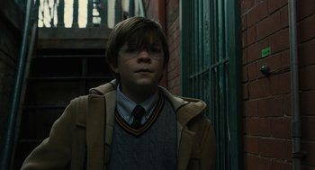 Movie still from “The Goldfinch” (2019), directed by John Crowley – A young man wearing glasses and a sweater; Close Up shot, Low angle