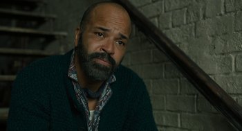 Movie still from “The Goldfinch” (2019), directed by John Crowley – A man with a beard is sitting in a room; Close Up shot, High angle