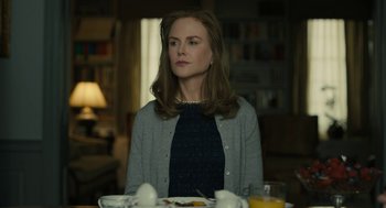 Movie still from “The Goldfinch” (2019), directed by John Crowley – A woman sitting at a dining room table; Medium shot, Low angle