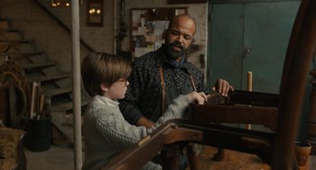 Movie still from “The Goldfinch” (2019), directed by John Crowley – A man and a boy working in a workshop; Medium shot, Over the shoulder angle