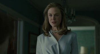 Movie still from “The Goldfinch” (2019), directed by John Crowley – A woman in a white jacket and a pearl necklace; Close Up shot, Low angle