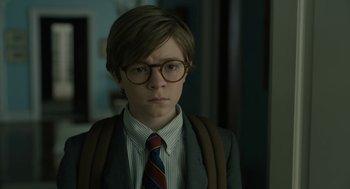 Movie still from “The Goldfinch” (2019), directed by John Crowley – A young man wearing a suit and tie with glasses; Close Up shot, Over the shoulder angle